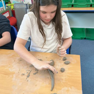 Children making clay lizards